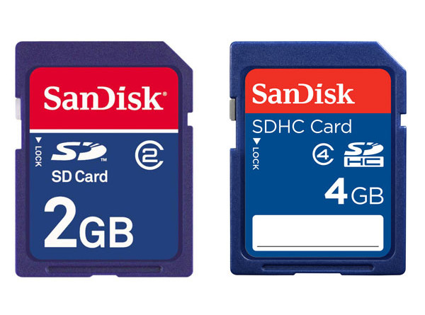 Karty pamięci Sandisk SD 2GB i SDHC 4GB. Pierwsza z nich posiada klasę szybkości 2, co oznacza minimalną prędkość zapisu na poziomie 2 MB/s. W przypadku drugiej karty szybkość gwarantowana to zapis na poziomie przynajmniej 4 MB/s. Karty pamięci o tych parametrach w zupełności wystarczą do naszych codziennych zastosowań.